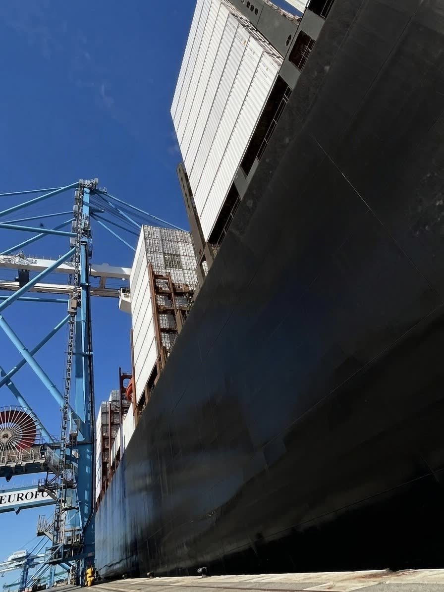 Porte-conteneurs à quai vu depuis le quai, portiques de manutention en arrière-plan